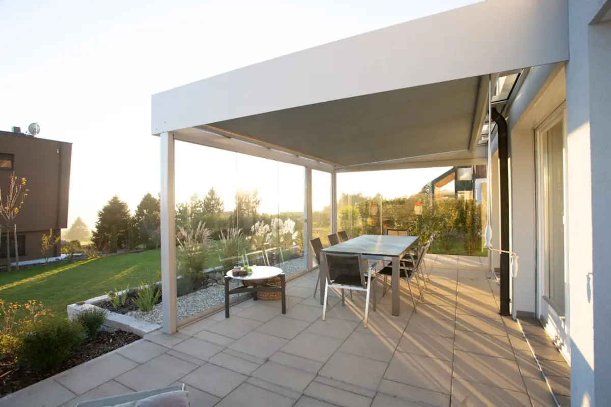 Bílá hliníková pergola s pevnou střechou nad terasou domu